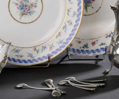 une théière en argent et un service à thé en argent posés sur une table