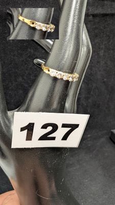 une main tenant une paire d'anneaux sur lesquels figure un chiffre