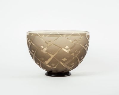 brown glass bowl with geometric design on black base on white background