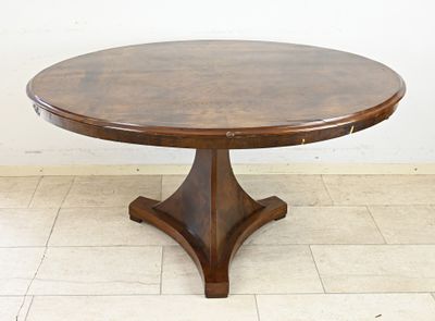a round table with a wooden base on a tiled floor