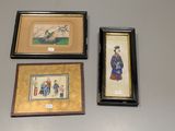trois tableaux encadrés accrochés au mur d'une pièce, à côté d'un mur