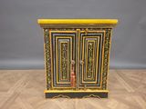 yellow and black painted cabinet on wooden floor against grey wall