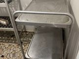 a metal cart that is sitting in the corner of a room