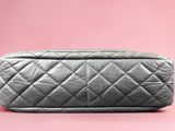 grey quilted cosmetic bag on pink background
