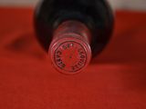 a close up of a bottle of wine on a red cloth