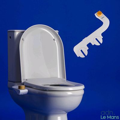 des toilettes blanches sur lesquelles est posée une clé, avec un mur bleu en arrière-plan