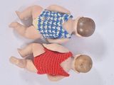two dolls that are laying next to each other on a table