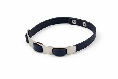 un gros plan sur un bracelet en cuir noir muni d'un fermoir en métal