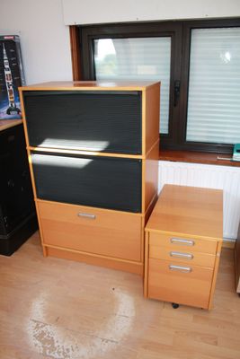 a desk with a computer on top of it in a room