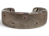 a close up of a silver bracelet with pink stones on it