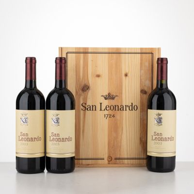 three bottles of red wine in front of a wooden box