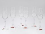 six wine glasses with red and white designs on them on a white surface