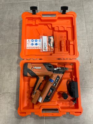 une boîte à outils orange contenant une agrafeuse, une agrafeuse et une cloueuse