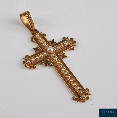 une image représentant une croix en or ornée de perles, posée sur un fond blanc