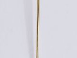 a gold pin with a flower on it on a white surface