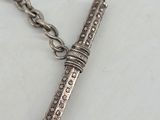 a close up of a silver cross on a chain on a table