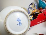 a white bowl with blue writing on it next to a red box