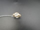 a close up of a ring with a diamond on a table