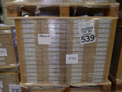 a stack of boxes with price tags on them in a warehouse