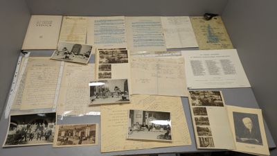 une table sur laquelle sont posées de nombreuses vieilles photos et de nombreux vieux papiers
