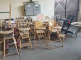 many wooden chairs and ladders in a room