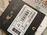 a black box with a barcode on it sitting on top of a blanket