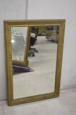 un miroir posé sur le sol à côté d'une chaise
