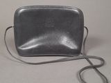grey leather purse with a strap on a white surface