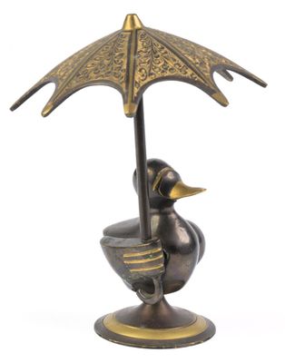 une statue représentant un canard avec un parapluie, posée sur un socle