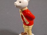 a small figurine of a white bear wearing a red jacket