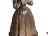 three figurines of a woman in a dress and a man in a hat