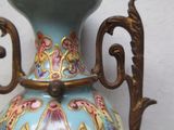 un vase bleu orné de motifs dorés, posé sur une table