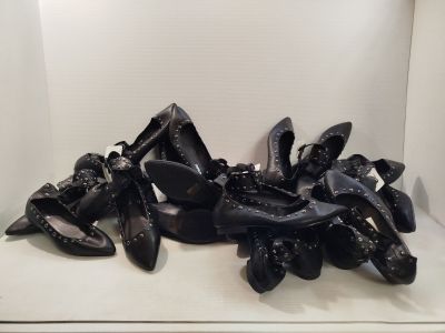 une pile de chaussures noires posées sur une étagère