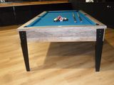 a pool table with a blue cloth on it in a room