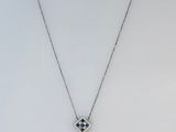 a white necklace with a silver chain and a pendant with an evil eye on it