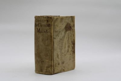 an old book sitting on top of a table on a white surface