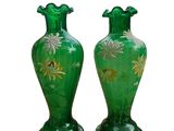 une paire de vases verts ornés de fleurs dorées sur fond blanc