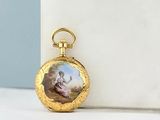 an image of a gold pocket watch with a picture of a woman on it