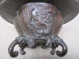 a metal vase with a dragon on it on a table