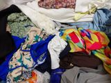 a pile of clothes that is sitting on a bed