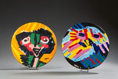 deux assiettes colorées, ornées de visages peints, posées sur une table