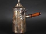 une cafetière ancienne en argent avec une poignée en bois