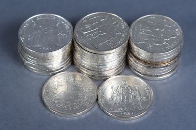 several stacks of silver coins sitting on top of each other on a blue surface