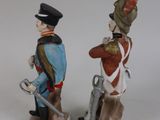 two figurines of men in uniforms are standing next to each other