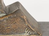 sculpture of a bird on a wooden base with a white background