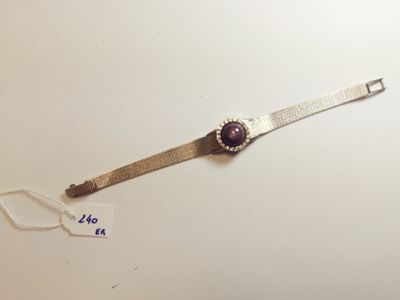 an image of a silver watch with a purple stone on it