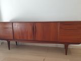 un buffet en bois à deux tiroirs et un miroir accroché au mur