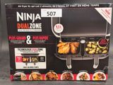 emballage représentant une boîte noire et blanche avec l'image d'un grill et d'une assiette de nourriture