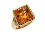 un gros plan d'une bague en or sertie d'une topaze orange