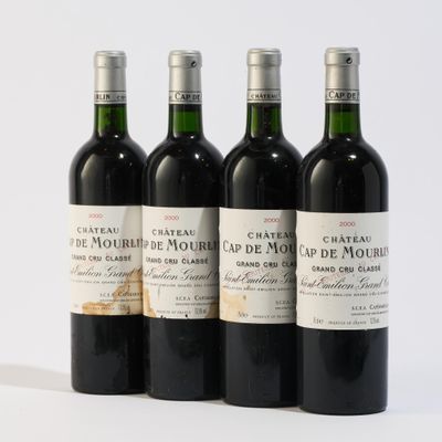 quatre bouteilles de vin sont alignées sur une surface blanche